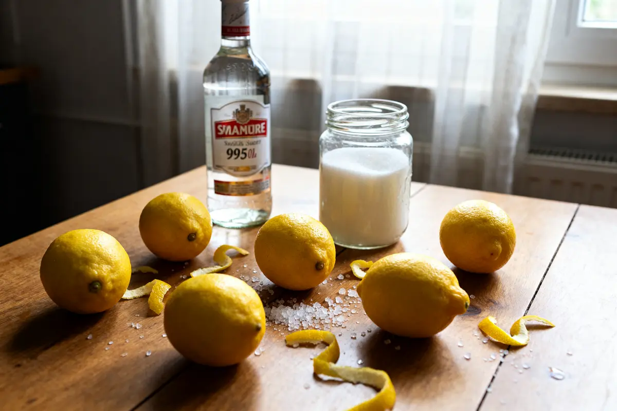 Citron, sucre, alcool sur table pour recette de limoncello maison et authentique